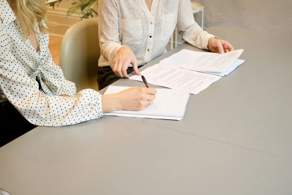 A professional assisting a client with assessment paperwork