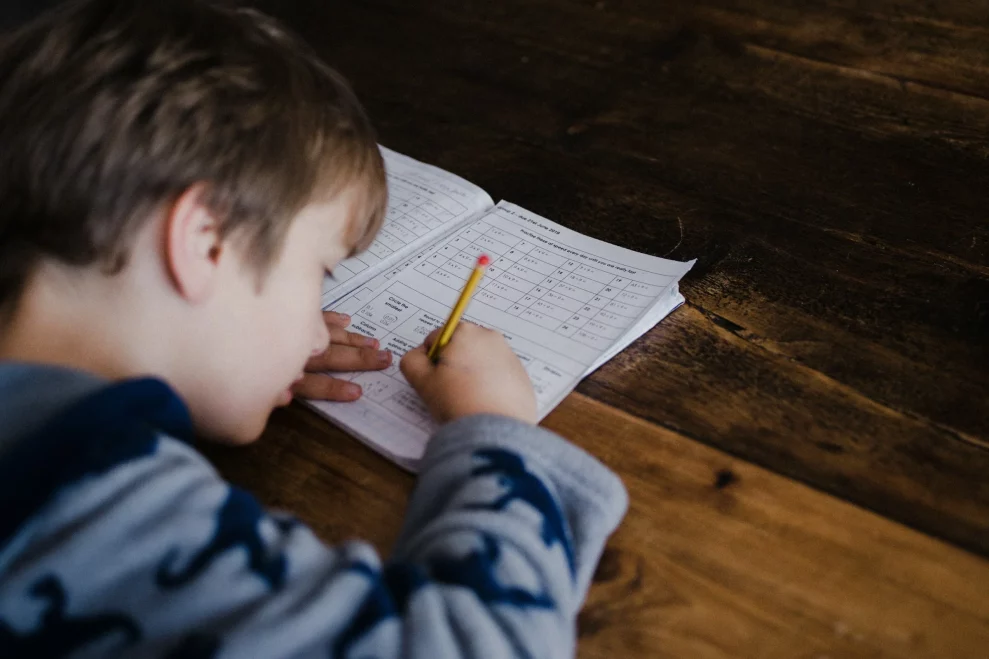 A child concentrating while completing mathematics homework