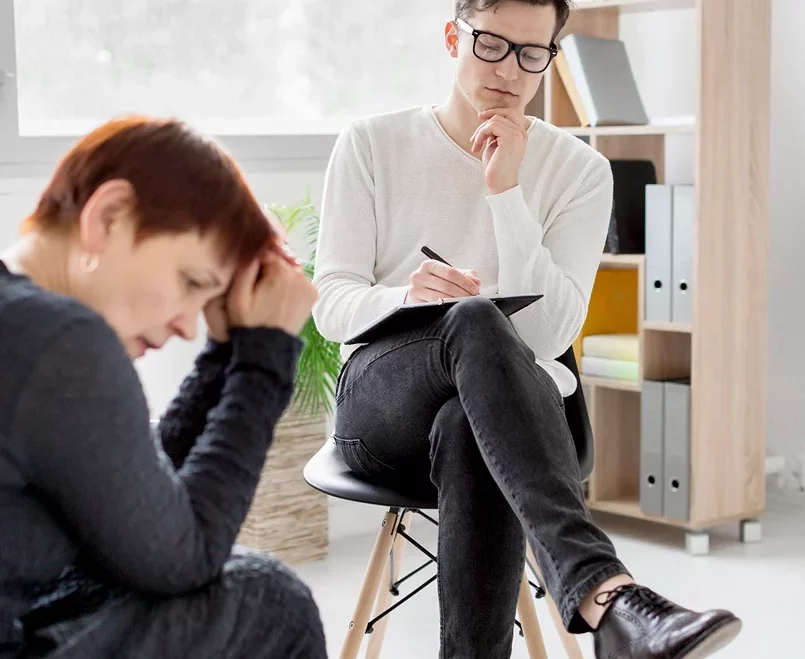 A clinician listening to a student during a psychological evaluation